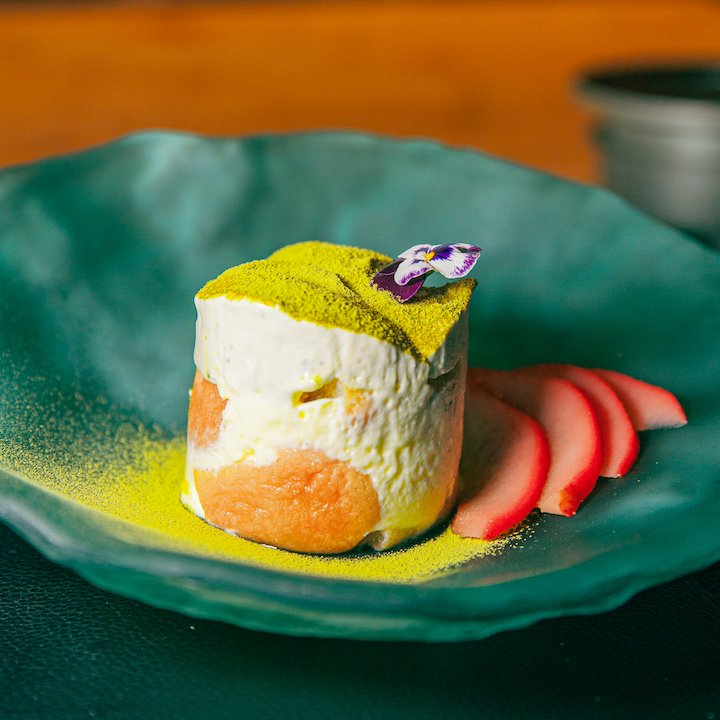 A sake-infused matcha tiramisu on a glass plate