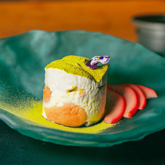 A sake-infused matcha tiramisu on a glass plate