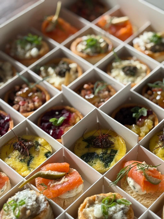 Assorted small canapes in a grid on a white background