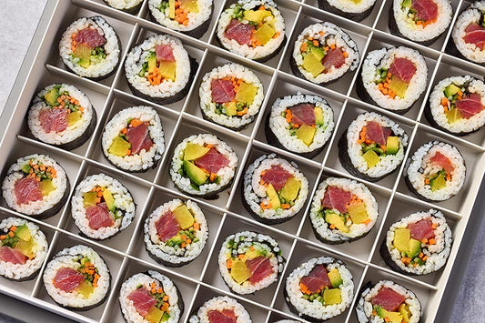 Assorted futomaki sushi rolls in a grid on a tray