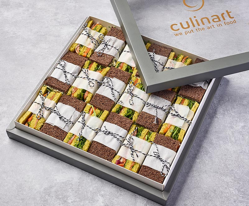 Box of assorted mini sandwiches with 'culinart' branding on a gray background