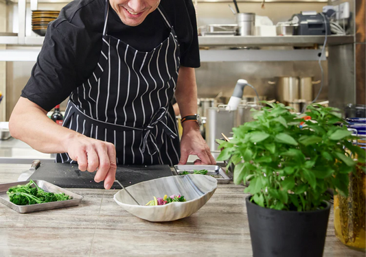 Chef preparing a meal in a bowl