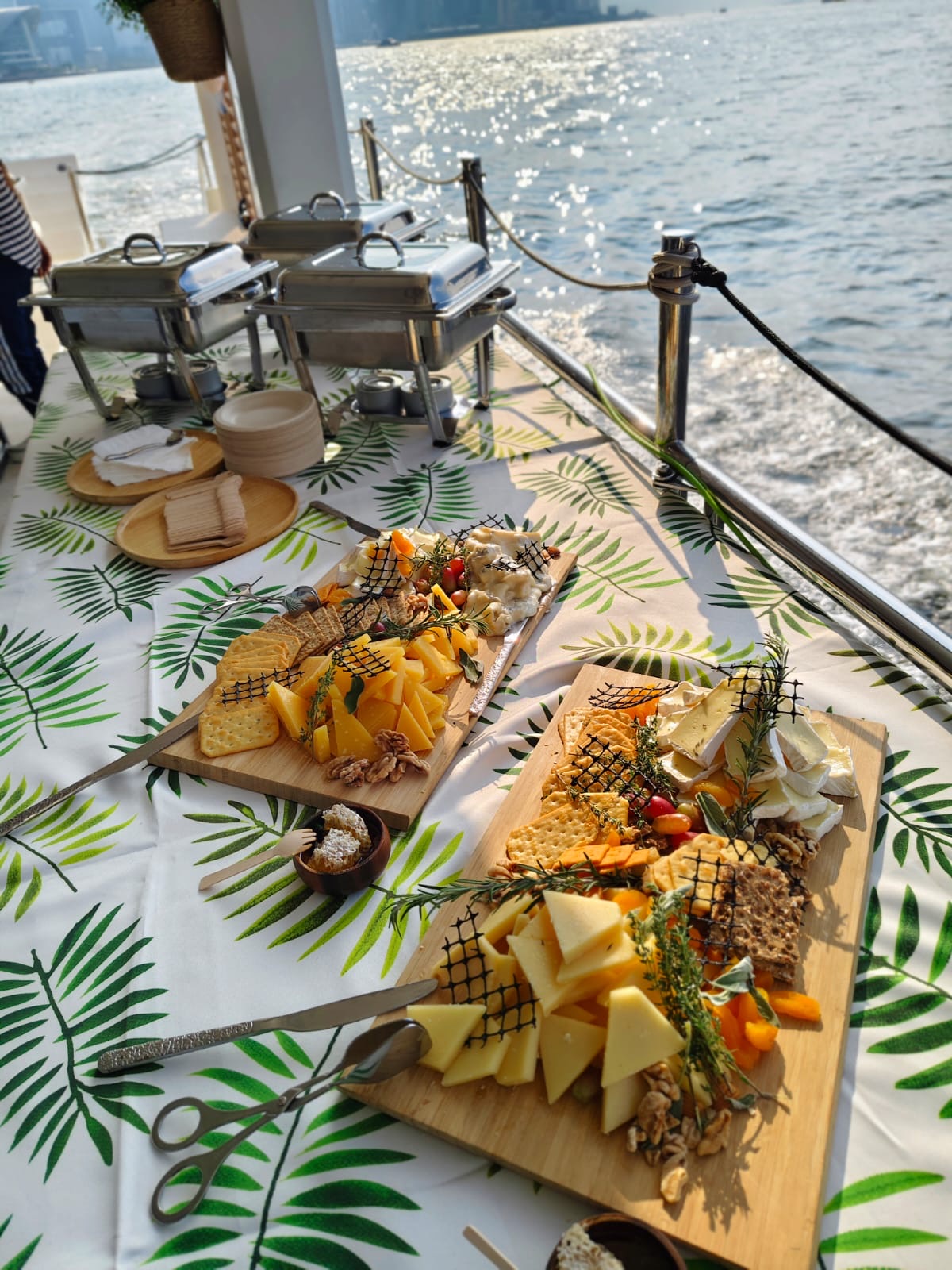 A catered buffet of bread, cold cuts and cheese spread on a table of a yacht