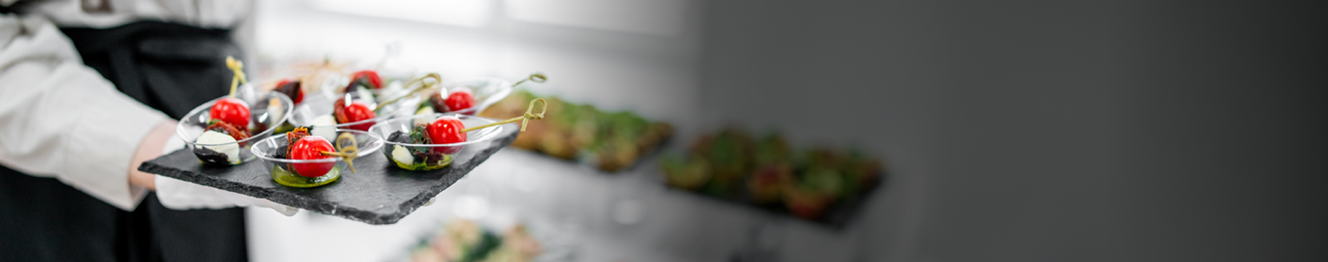 Person holding a tray of appetizers with blurred background